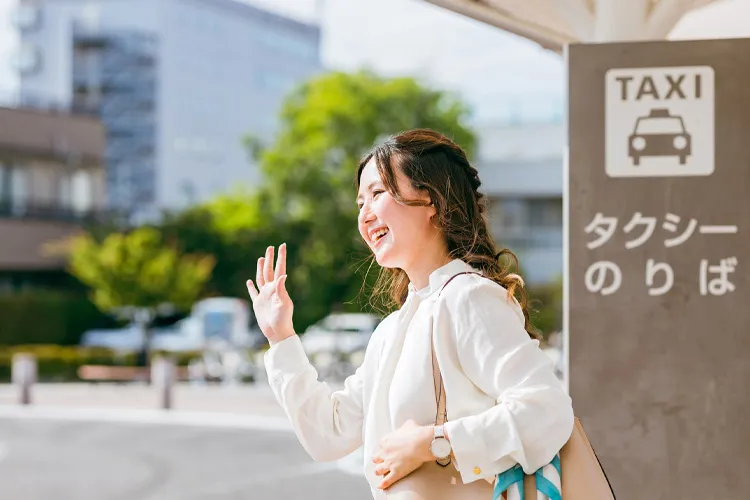 タクシー乗り場でタクシーを待つ女性