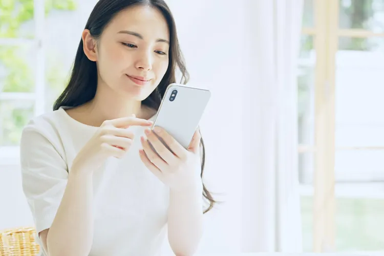 スマートフォンで観光ツアーを予約する女性のイメージ