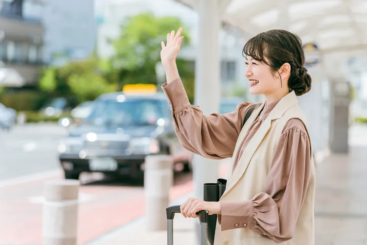 タクシーを停める女性