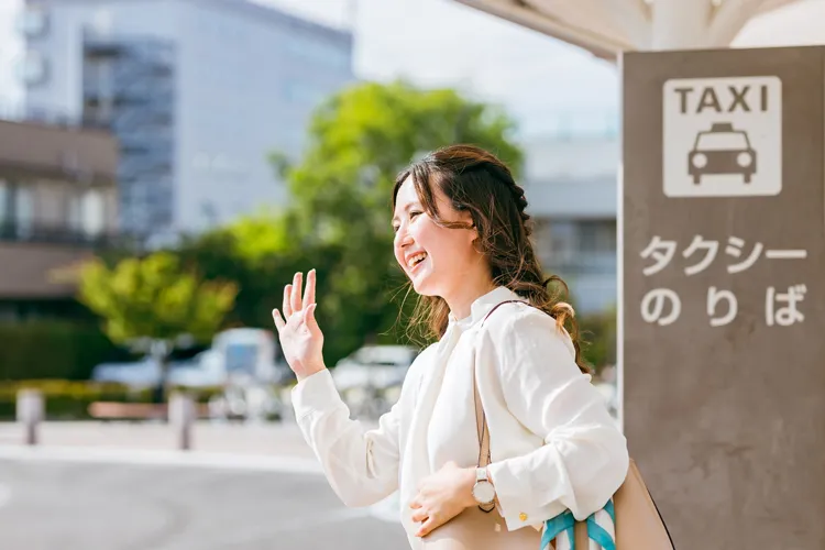 タクシーのりばでタクシーを待つ女性