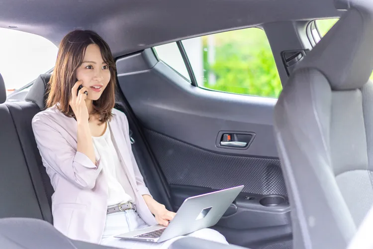 タクシーの車内で電話をするビイジネスマン