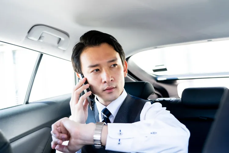 タクシーの車内で電話するビジネスマン