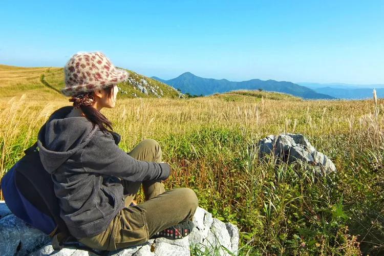 山頂でくつろぐ一人旅の女性