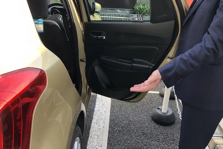 ハイヤーのドアを開けるドライバー