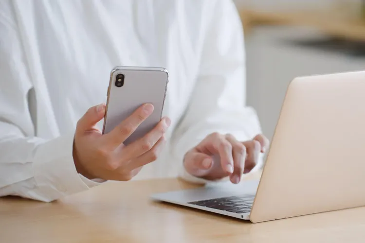 スマホを見ながらPCで予約する男性