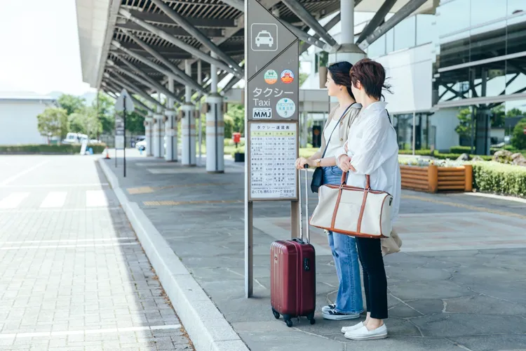 空港でタクシーを待つ2人の女性