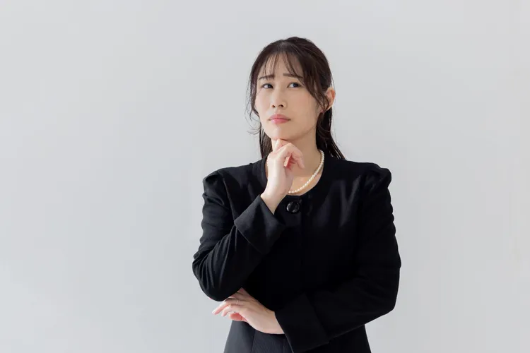 悩む喪主の女性