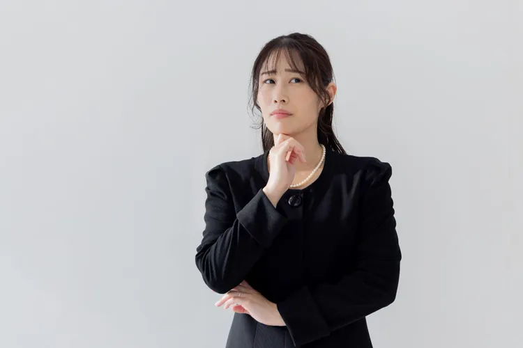 考える喪服の女性