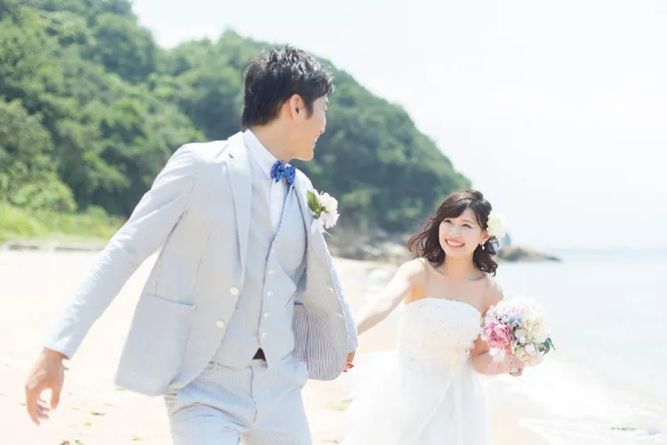 ビーチを歩く新郎新婦