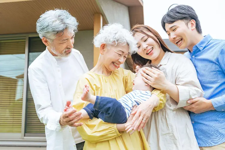 祖父母に抱かれる赤ん坊とその夫婦